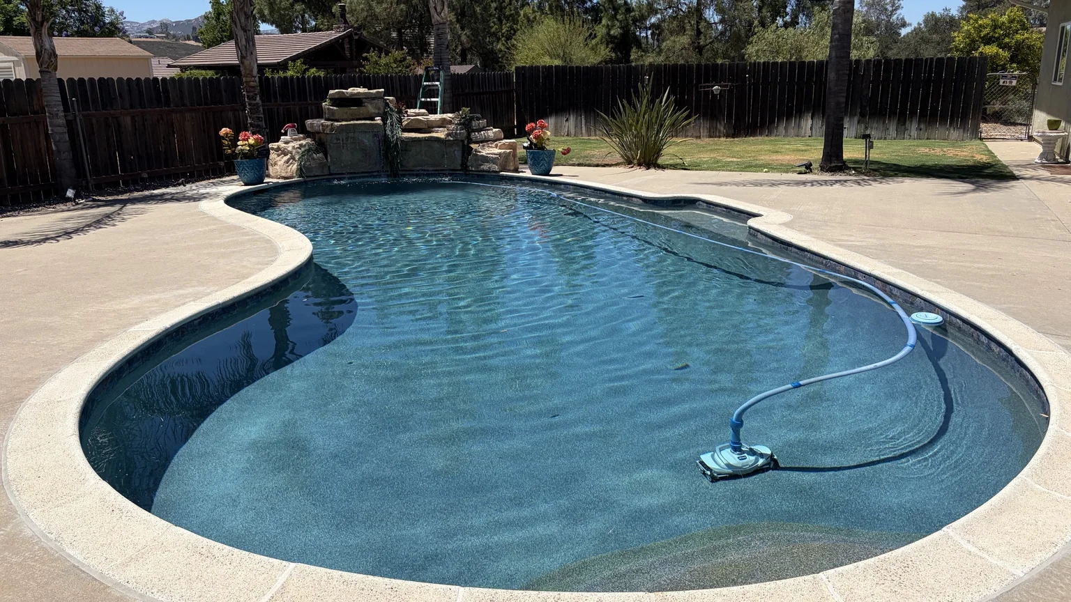 Swimming pool with waterfall at The Pilot Cottage property